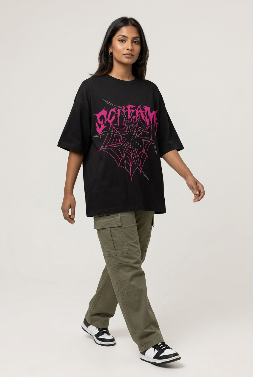 Pink gothic spiderweb oversized tee with olive cargo pants, walking pose