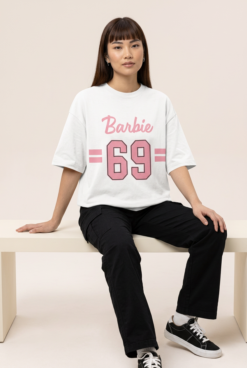 Pink varsity 69 tee with black cargo pants, seated model