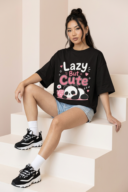 Black Lazy But Cute panda oversized tee, seated model on steps