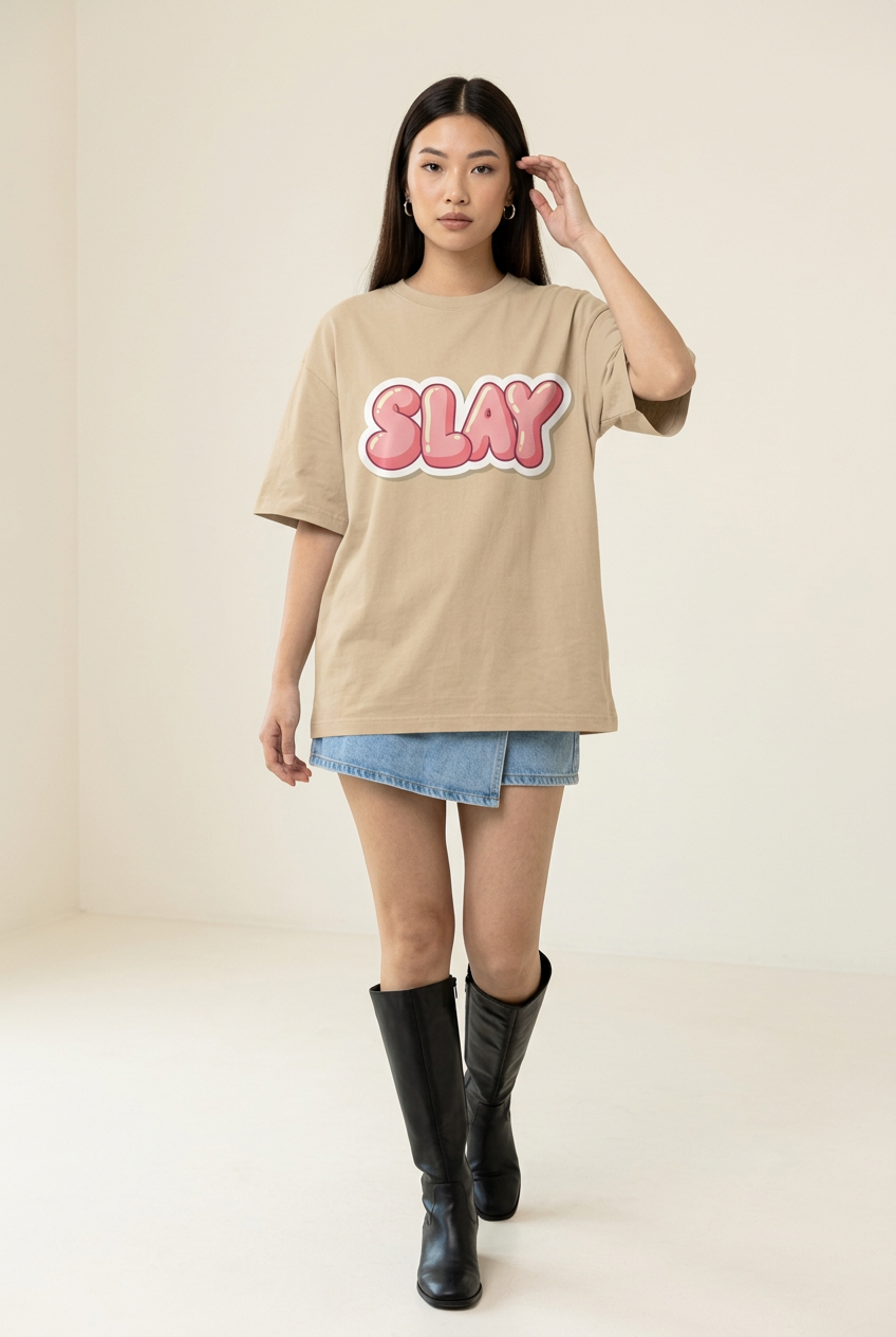 Pink Slay tee styled with denim skort and tall boots, walking pose